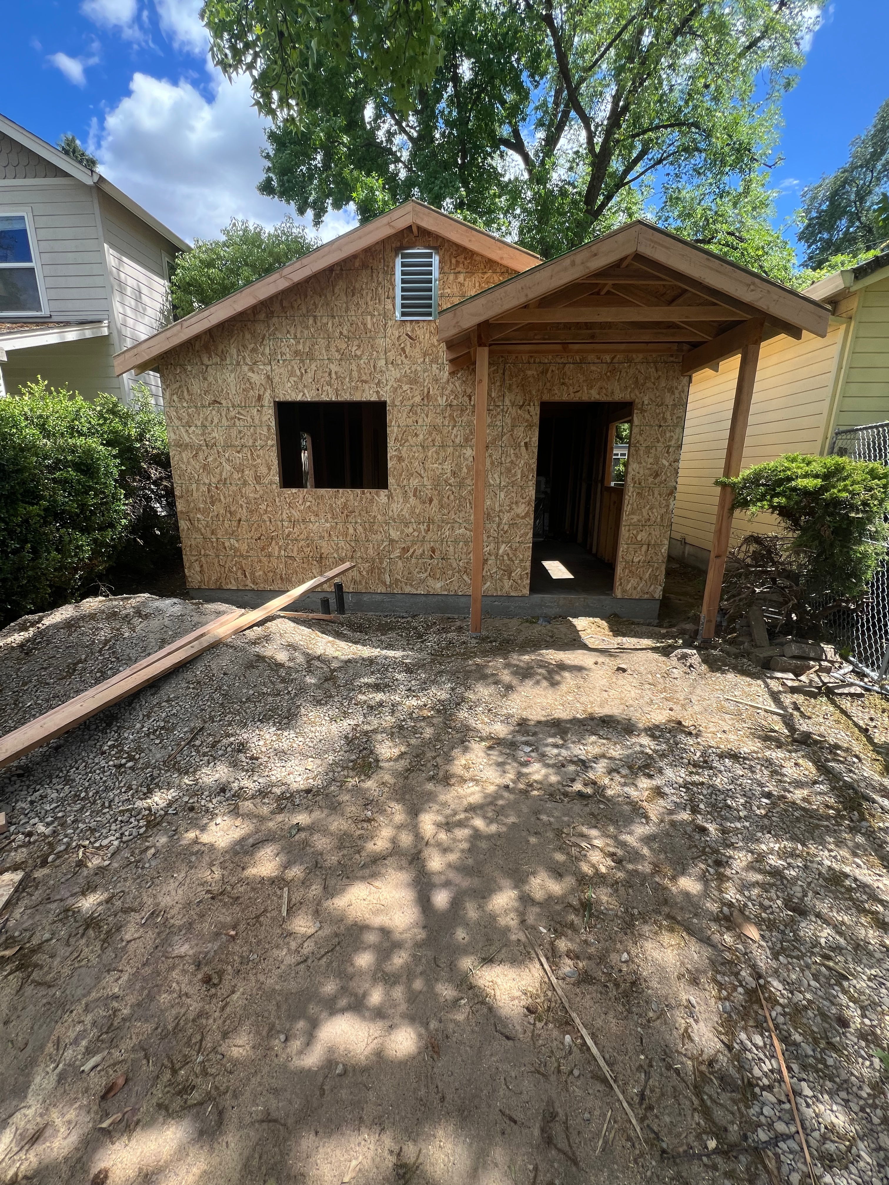 ADU construction in Chico, CA with framing, OSB sheathing, gable roof, and porch structure completed during the rough‑in phase.